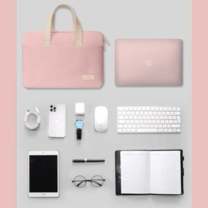 Sacoche PC portable 14 pouces rose poudrĂ© posĂ©e Ă  cĂŽtĂ© dâun ordinateur et accessoires de bureau.